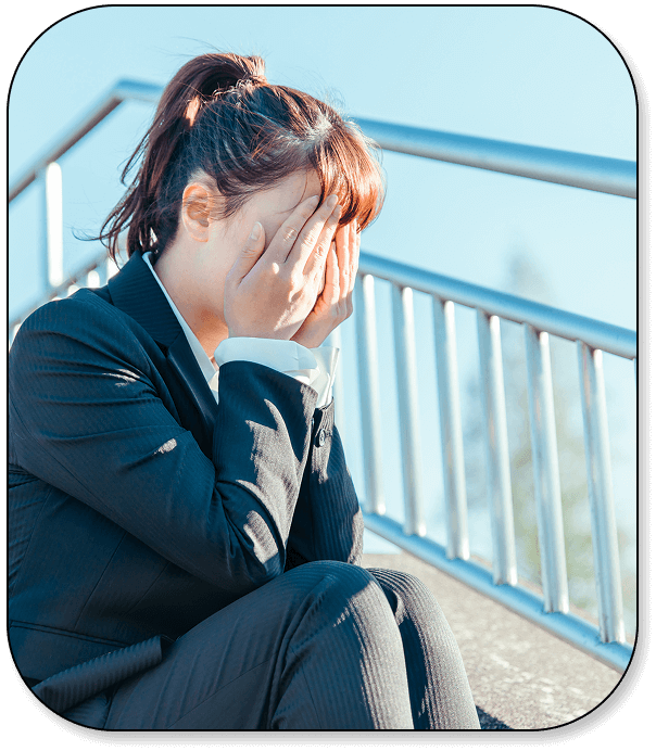 上手くいかず、階段で顔を覆う女性